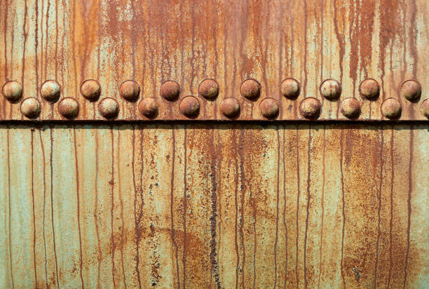 High resolution photograph of a steel surface with rivets.