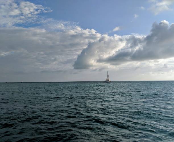 istock Sailboat on the horizon with clouds 1019982922