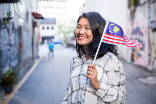istock One girl holding Malaysian Flag 1019995204