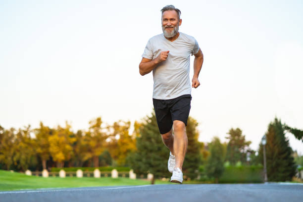istock The smiling happy elderly man running on the road 1019998694