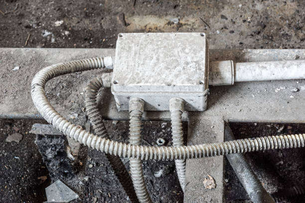 istock White electric box with three black cables on the old red brick wall. 1020001014