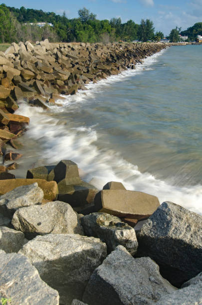 istock wave crushing concrete breakwater on the beach over blue sky background at sunny day 1020002072