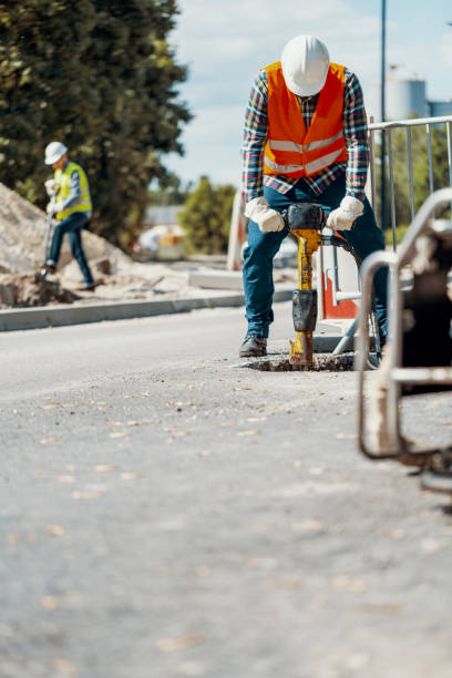 Asian female worker  working road construction worker using a jackhammer