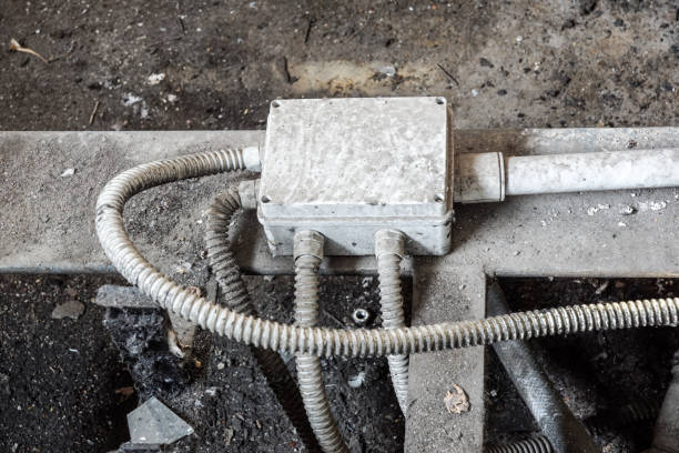 istock White electric box with three black cables on the old red brick wall. 1020005820