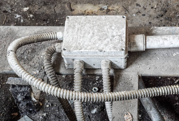 istock White electric box with three black cables on the old red brick wall. 1020011074