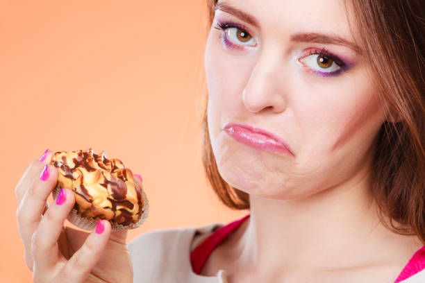 istock unhappy woman holds cake in hand 1020014992