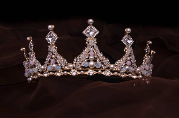 golden crown with pearls and beads isolated on the fabric golden crown with pearls and beads isolated on the fabric princess crown tiara prom stock pictures, royalty-free photos & images