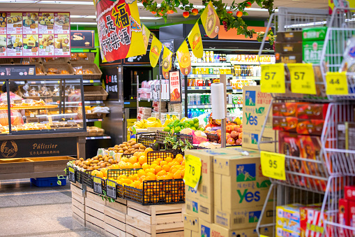 A bright supermarket in the community, displaying a wide range of fruits and vegetables and goods