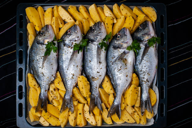 Fish Sparus aurata for baking with potatoes and greens