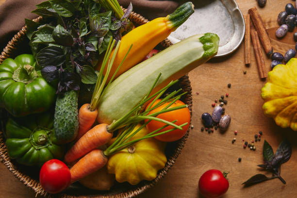 istock Basket filled with farm vegetables on wooden table 1020038226