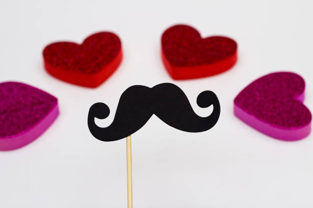 istock Photo booth props Black Mustache against blurred hearts on white background 1020040942