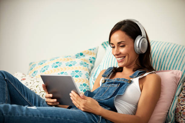 istock Smiling woman using tablet while listening music 1020046234