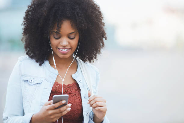 istock Afro Caribean young woman texting a message. 1020049964