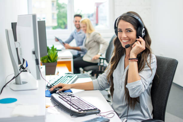 istock Smiling friendly female call-center agent with headset working on support hotline in the office 1020050330