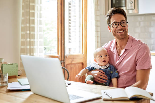istock Father and son with laptop looking away at table 1020050456