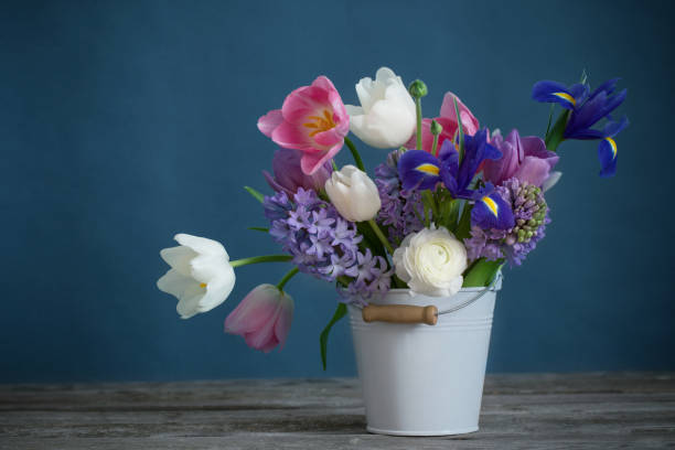 istock spring flowers in bucket on gray background 1020063360