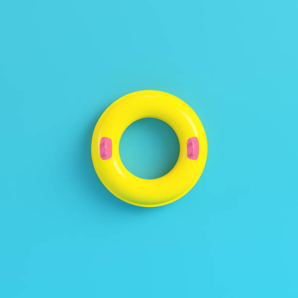 Yellow inflatable ring on bright blue background in pastel colors stock photo