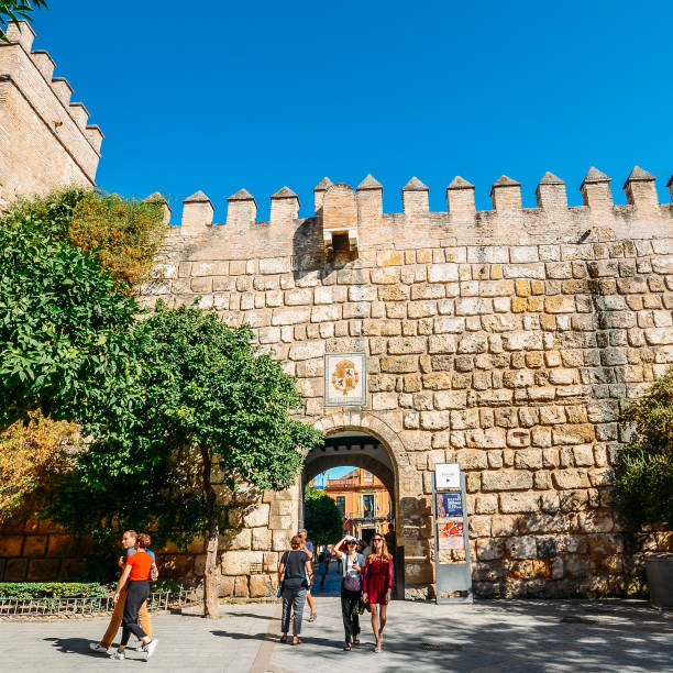 Tourists at fortified entrance to the Alcazar Complex - UNESCO World Heritage Site Seville, Spain - July 14th, 2018: Tourists at fortified entrance to the Alcazar Complex - UNESCO World Heritage Site el alcazar palace seville stock pictures, royalty-free photos & images