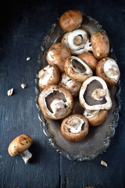 istock Fresh button mushrooms on antique tray and old wood table 1020083750