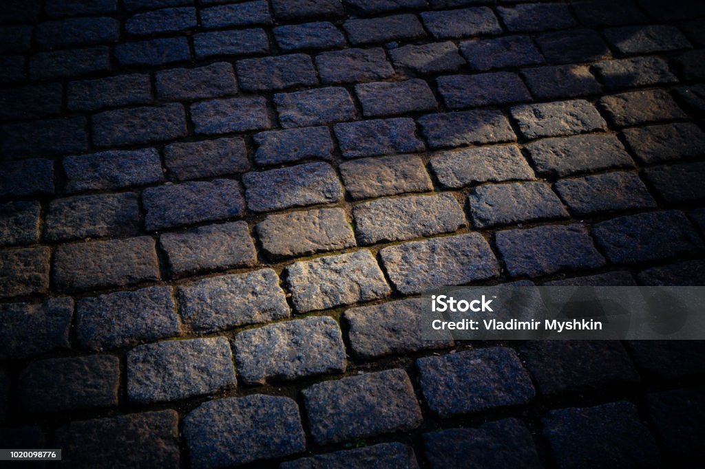 ancient cobblestone pavement Ancient stone granite pavement with a stone of different colors Ancient Stock Photo