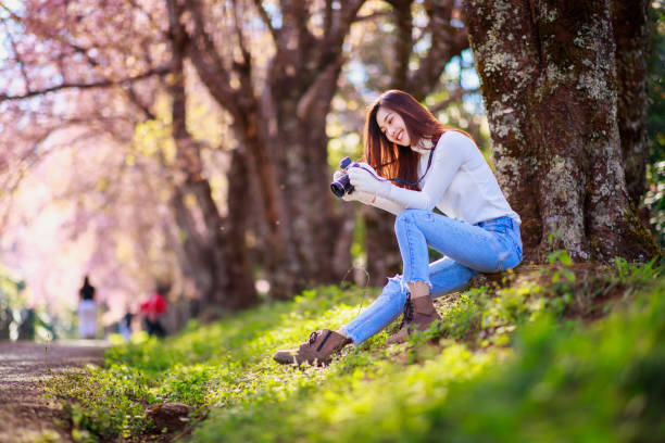 Beautiful Thai photographer is sitting for resting while carrying camera