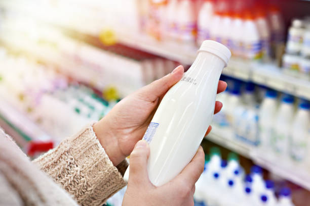 buyer hands with bottle of milk at grocery - milk bottle fotos imagens e fotografias de stock