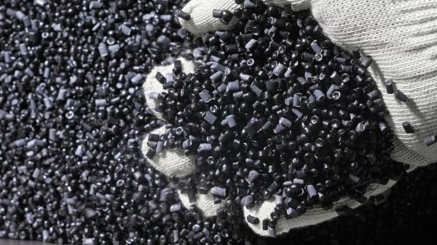 Plastic black gray granulated crumb. Manufacture of plastic water pipes factory. Process of making plastic tubes on the machine tool with the use of water and air pressure. stock photo