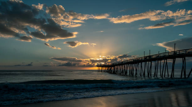 istock Light rays burst from the clouds in an ocean sunrise scene. 1020118454