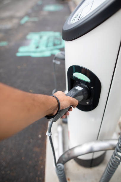 istock Man charging electric car at charging station 1020163334