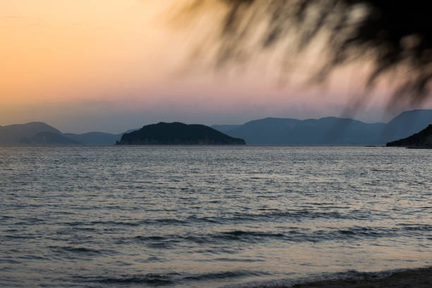 istock Dramatic sunrise with mist on the beach with rocks 1020163884