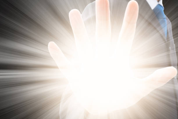 Businessman in dark gray suit raise his hand and the light of power explode out.