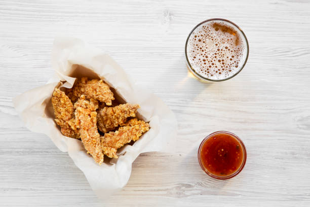 istock Top view chicken strips with sauce and cold beer on a white wooden table. Overhead, from above. 1020183220