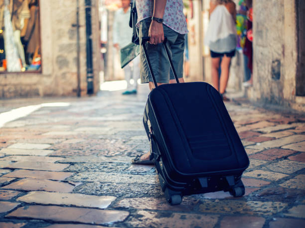 istock Tourist walking with suitcase on the street 1020186430