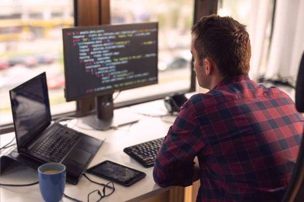 Software developer working Software developer working in a modern office broadcast programming stock pictures, royalty-free photos & images