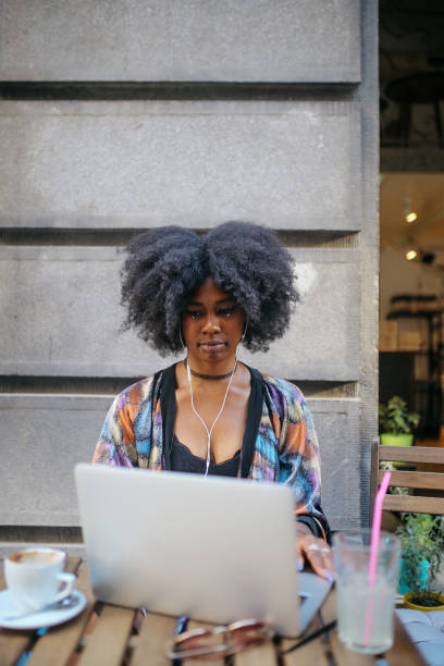 istock Young digital nomad woman sitting in a cafe, relaxing, doing freelance work on a laptop 1020191814