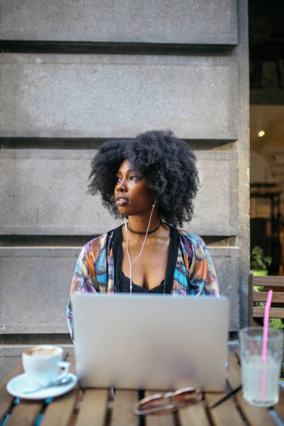 istock Young digital nomad woman sitting in a cafe, relaxing, doing freelance work on a laptop 1020191818