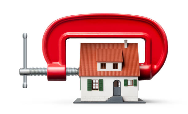 istock House being squeezed in a g clamp on white background 1020197066