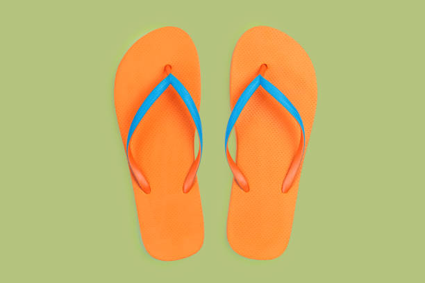 Pair of orange thongs sandals isolated on white background