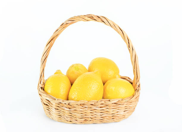 istock Ripe lemons in wicker basket on white isolated background. 1020206834