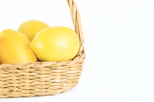 istock Ripe lemons in wicker basket on white isolated background. 1020206890