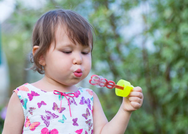 istock Cute little girl is blowing a soap bubbles 1020229966