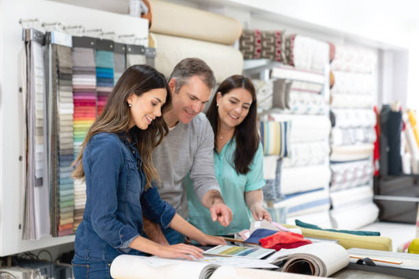 Interior designer with a couple choosing fabrics for a house project