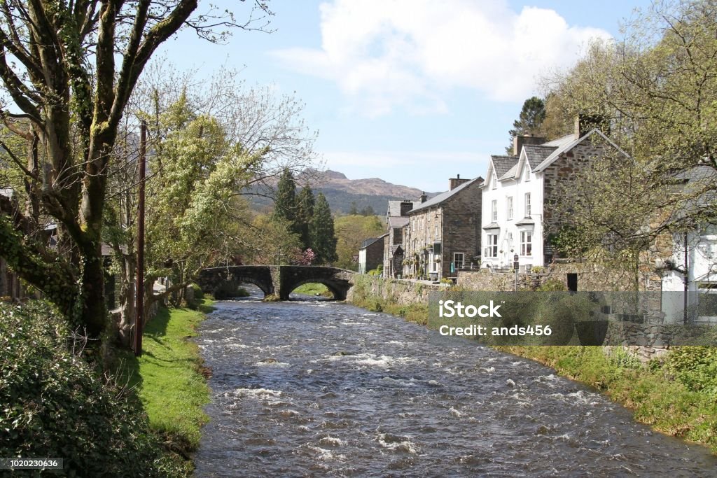 Beddgelert village in Snowdonia National Park, Wales picturesque village of Beddgelert with the river Glaslyn running through it, in Snowdonia National Park, Wales , traditional slate and stone buildings visible Village Stock Photo