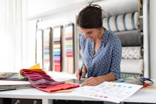 istock Fashion designer working on a project and choosing fabrics at a textile shop 1020233400