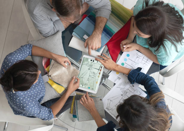 istock Group of interior designers working on a house project and looking at a sketch 1020233410