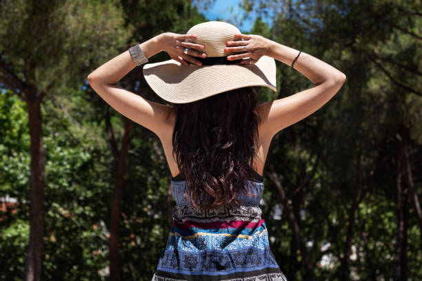 istock Beautiful young woman holding her hat with both hands 1020233700