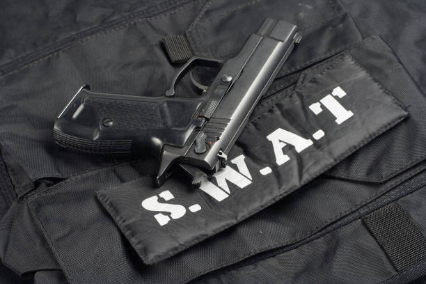 istock SWAT handgun on black uniform background 1020238550