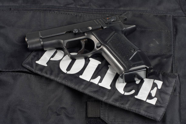 istock police handgun on black uniform background 1020238566