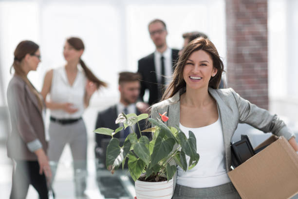 istock happy business woman with box on office background 1020243664