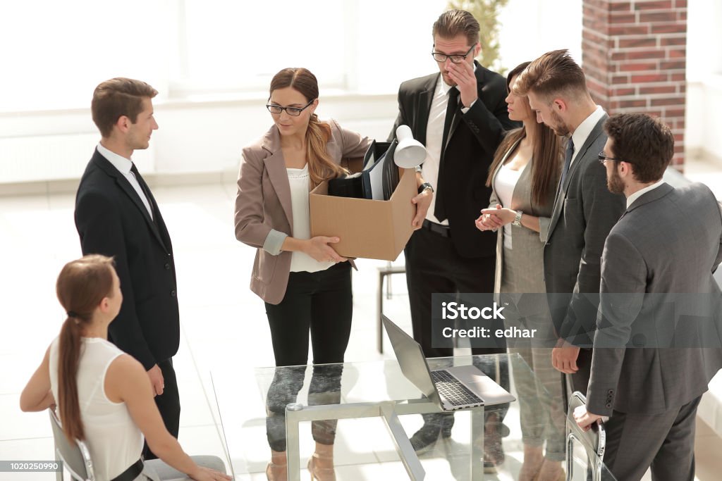 fired employee with personal things standing in the office fired employee with personal things standing in the office.business concept Leaving Stock Photo
